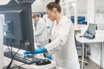 female doctor working in a modern equipped computer laboratory analyzes blood samples and genetic materials using special machines in a modern laboratory.	