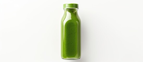 A top down view of a glass bottle filled with organic green juice on a white surface ideal for adding text or other elements to the image. Copy space image. Place for adding text and design