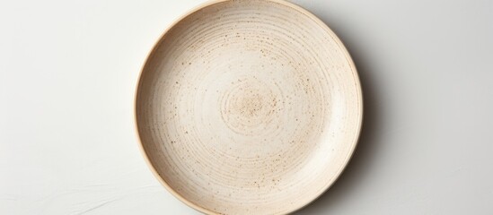 Neutral beige pottery plate on a white studio backdrop in a high angle view for food styling in advertising with copy space image