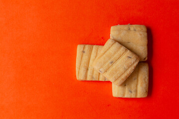 Stacked Cumin Cookies or Indian Jeera Cookies, on an orange background. Top-down view. Food Flat lay.