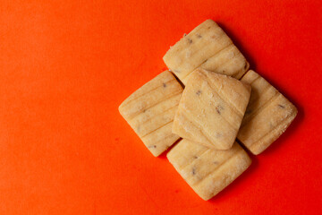 Stacked Cumin Cookies or Indian Jeera Cookies, on an orange background. Top-down view. Food Flat lay.