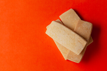 Stacked coconut butter cookies, on an orange background. Top-down view. Food Flat lay.