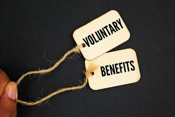 wooden tag with the word Voluntary Benefits. the concept of profit