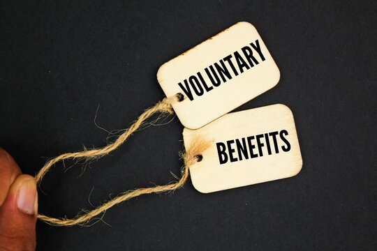 wooden tag with the word Voluntary Benefits. the concept of profit