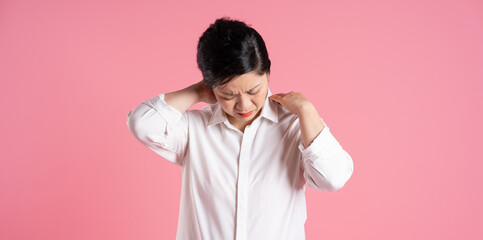 Image of older Asian businesswoman posing on pink background
