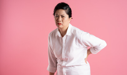 Obraz premium Image of older Asian businesswoman posing on pink background