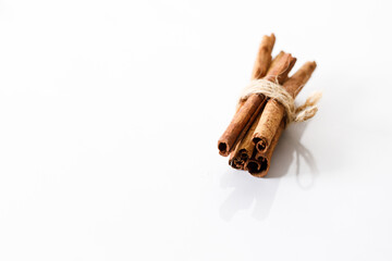 Cinnamon sticks dried tree bark spice on white table background. Selective focus.