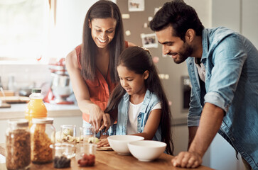 Parents, kid and happy in kitchen for breakfast with food for teaching or learning and bonding. Family, people and smile for support with care or trust for child development, growth and chill