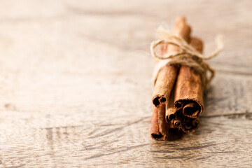 Cinnamon sticks dried tree bark spice on rustic wooden table background. Selective focus.