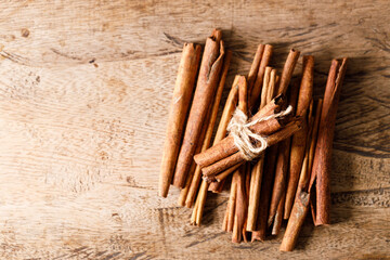 Cinnamon sticks dried tree bark spice on rustic wooden table background. Selective focus.