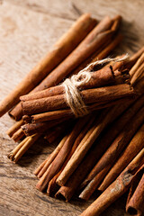 Cinnamon sticks dried tree bark spice on rustic wooden table background. Selective focus.