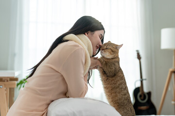 Caucasian beautiful woman holding and play with domestic cat in house. 