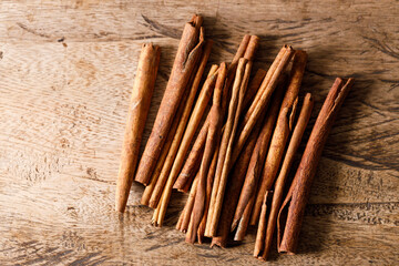 Cinnamon sticks dried tree bark spice on rustic wooden table background. Selective focus.