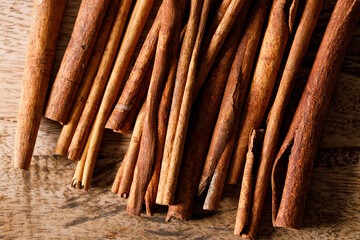 Cinnamon sticks dried tree bark spice on rustic wooden table background. Selective focus.