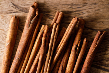 Cinnamon sticks dried tree bark spice on rustic wooden table background. Selective focus.