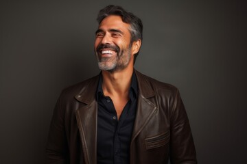 Fototapeta premium Portrait of a joyful man in his 40s sporting a stylish leather blazer over minimalist or empty room background