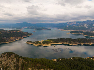 A dam lake in Turkey surrounded by forests. Fish cages in the lake. Cloudy sky. Karacaoren dam, Bucak, Burdur, Turkey.