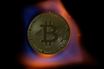 A bitcoin coin in the tongues of a hot flame. Real photo