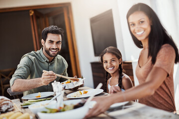 Fototapeta premium Parents, kid and portrait in home for dinner with food in dining table or room and bonding. Family, people and smile for support with care or trust and gather to relax, chill and happiness with meal