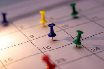 Side angle of Colorful Push pin in calendar. Calendar page pinned in calender on date, business...