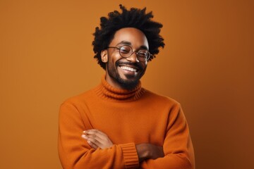 Obraz premium Portrait of a content afro-american man in his 30s wearing a cozy sweater while standing against solid color backdrop