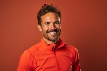 Obraz premium Portrait of a smiling man in his 30s sporting a technical climbing shirt in solid color backdrop