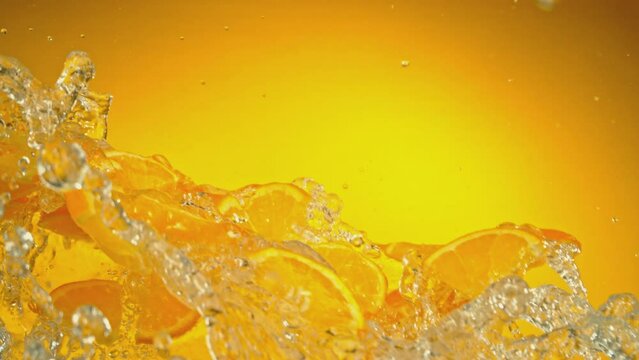 Super Slow Motion of Flying Orange Slices with Water Splashes, Isolated on Colored Background. Filmed on High Speed Cinema Camera, 1000fps.