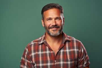 Obraz premium Portrait of a satisfied man in his 40s wearing a comfy flannel shirt over solid color backdrop