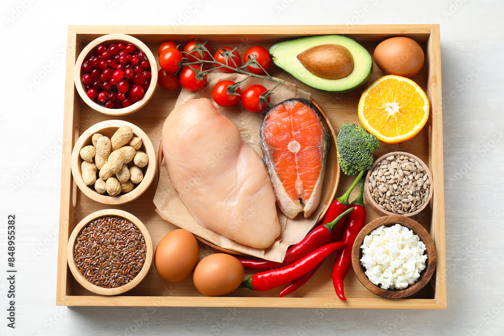 Wall mural tray with many different healthy food on white table, top view