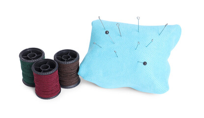 Pincushion, sewing needles, pins and spools of threads isolated on white