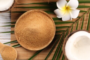 Coconut sugar, palm leaves, fruits and bamboo mat on table, flat lay