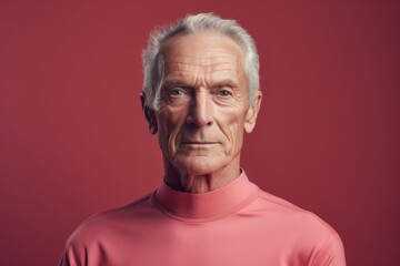 Obraz premium Portrait of a content man in his 70s sporting a long-sleeved thermal undershirt in front of solid color backdrop