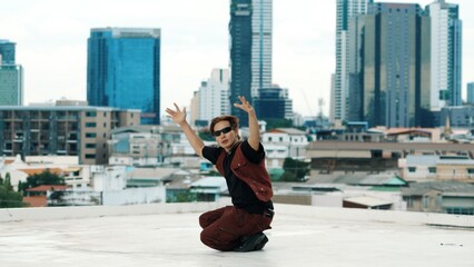 Professional asian break dancer practice B boy dance while multicultural friends at roof top. Young modern dancing group doing hip hop movement. Style,fashion,action. Outdoor sport 2024. Endeavor.