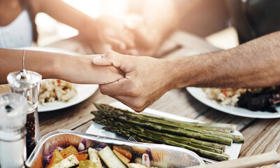 Hands, praying and food at table for faith, gratitude and worship together at home. Closeup, people and buffet in dining room for lunch, support and healthy meal in afternoon for Christianity