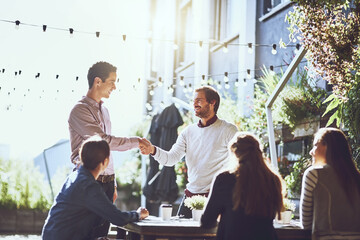 Business people, men and handshake in meeting at cafe for welcome, b2b networking or collaboration outdoor. Group, employees and shaking hands for onboarding, partnership deal and happy for agreement