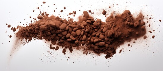 Coffee powder mixing with beans in mid air creating an abstract cloud with copy space image against a white background in high speed freeze frame shot