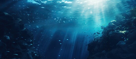 Fototapeta premium Underwater world in shades of cyan and dark marine blue with ink spreading through water enhanced by light casting circular gradients and depth ideal for copy space image