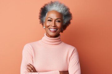 Portrait of a glad afro-american woman in her 60s wearing a classic turtleneck sweater in front of solid pastel color wall