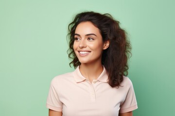Fototapeta premium Portrait of a happy woman in her 20s wearing a sporty polo shirt isolated on solid pastel color wall