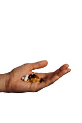 Young human hand holding vitamins pills in fingers. Healthcare, medical and pharmaceutical concept. Detailed closeup studio shot isolated on a white background.