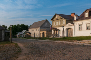 Obraz premium View of historical merchant buildings of estates on the main street of Izborsk Pechorskaya Street on a summer sunny day, Izborsk, Pskov region, Russia