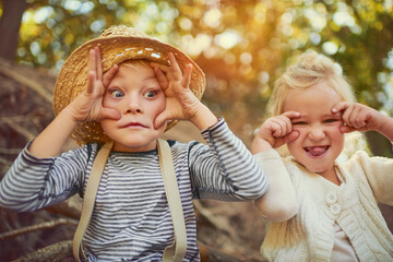Silly, boy and girl with funny face, friends and playful in nature, young and joy in summer and relax. Morning, outdoor and siblings on tree, portrait and happiness together, holiday and countryside