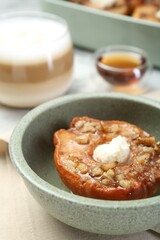 Tasty baked quince with nuts and cream cheese in bowl on table, closeup