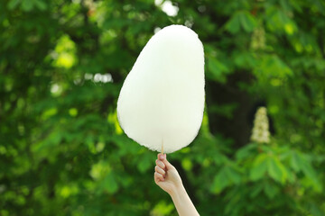 Woman holding sweet cotton candy outdoors, closeup