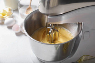 Making dough in bowl of stand mixer on white table, closeup