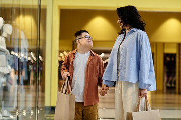 A mother and her son with Down syndrome walk hand-in-hand through a shopping mall, enjoying a day of shopping together.