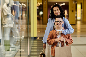 A mother and her son with Down syndrome smile for the camera while shopping in a mall.