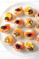 Different delicious puff pastry snacks on white table, top view