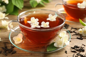 Hot jasmine tea in cups and flowers on wooden table