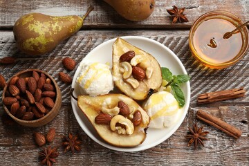 Delicious baked pears with nuts, ice cream, anise stars and honey on wooden rustic table, flat lay